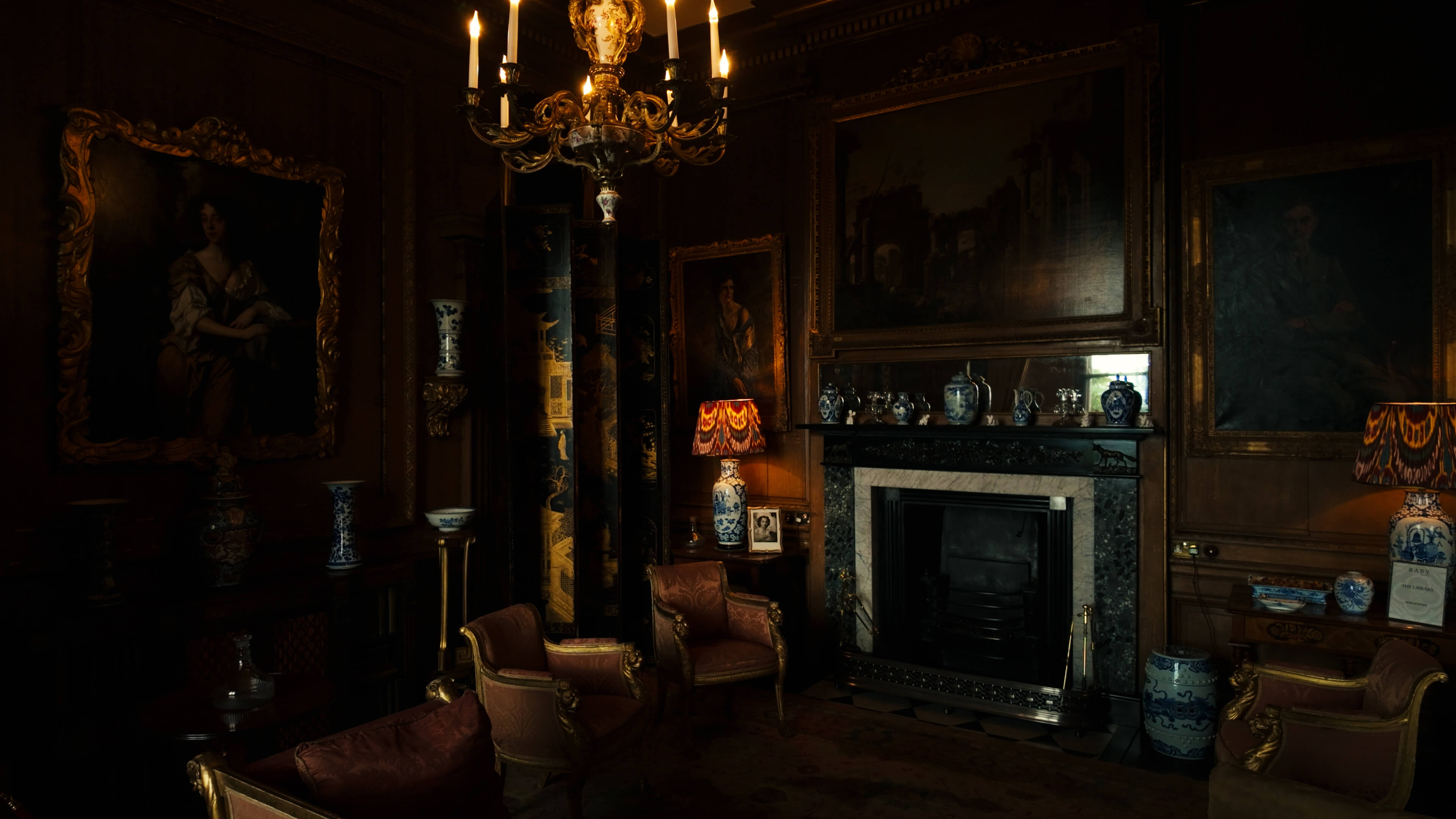 A cozy room featuring a warm fireplace and an elegant chandelier hanging from the ceiling