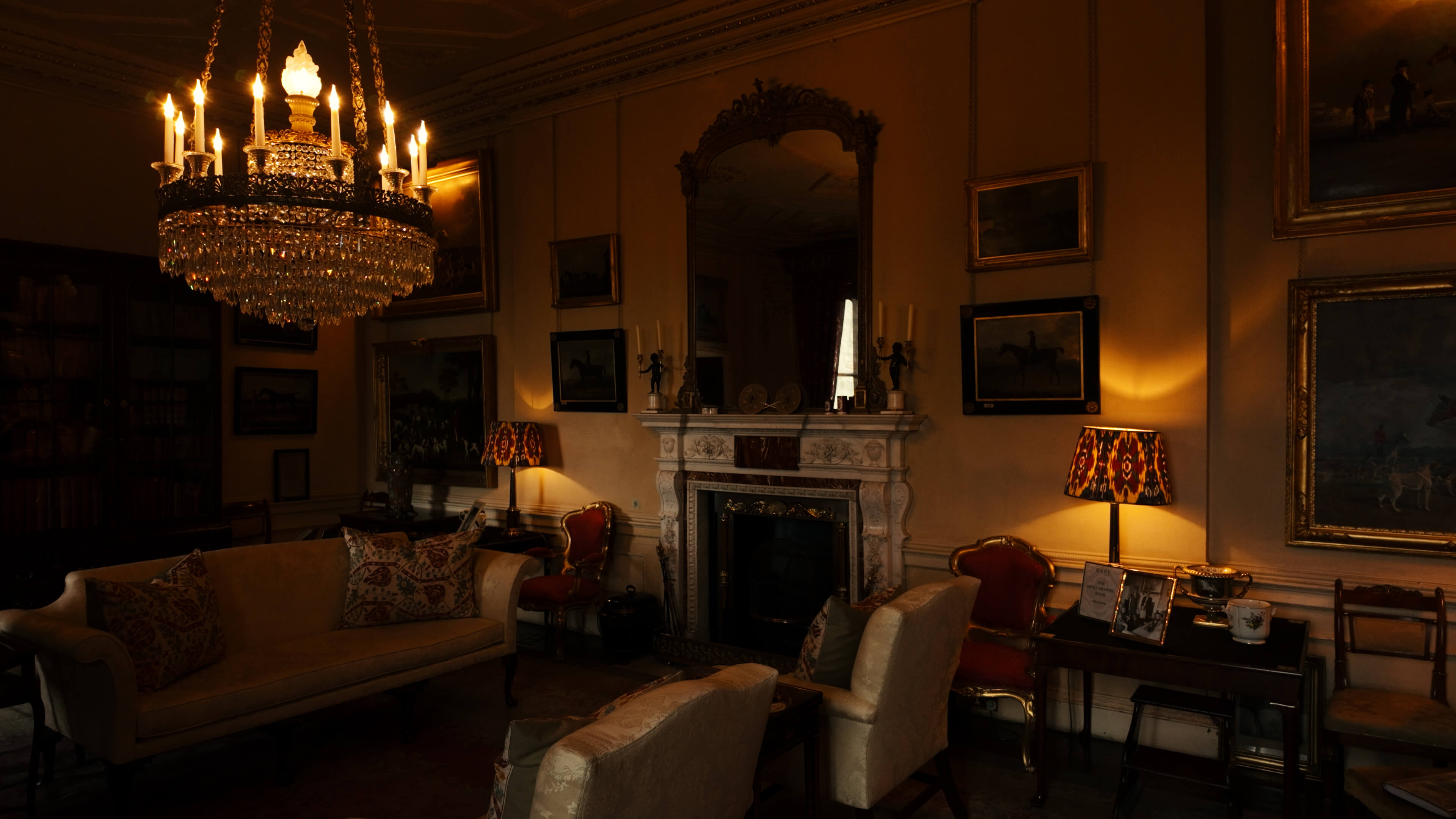 A cozy room featuring a fireplace, a plush couch, and an elegant chandelier hanging from the ceiling