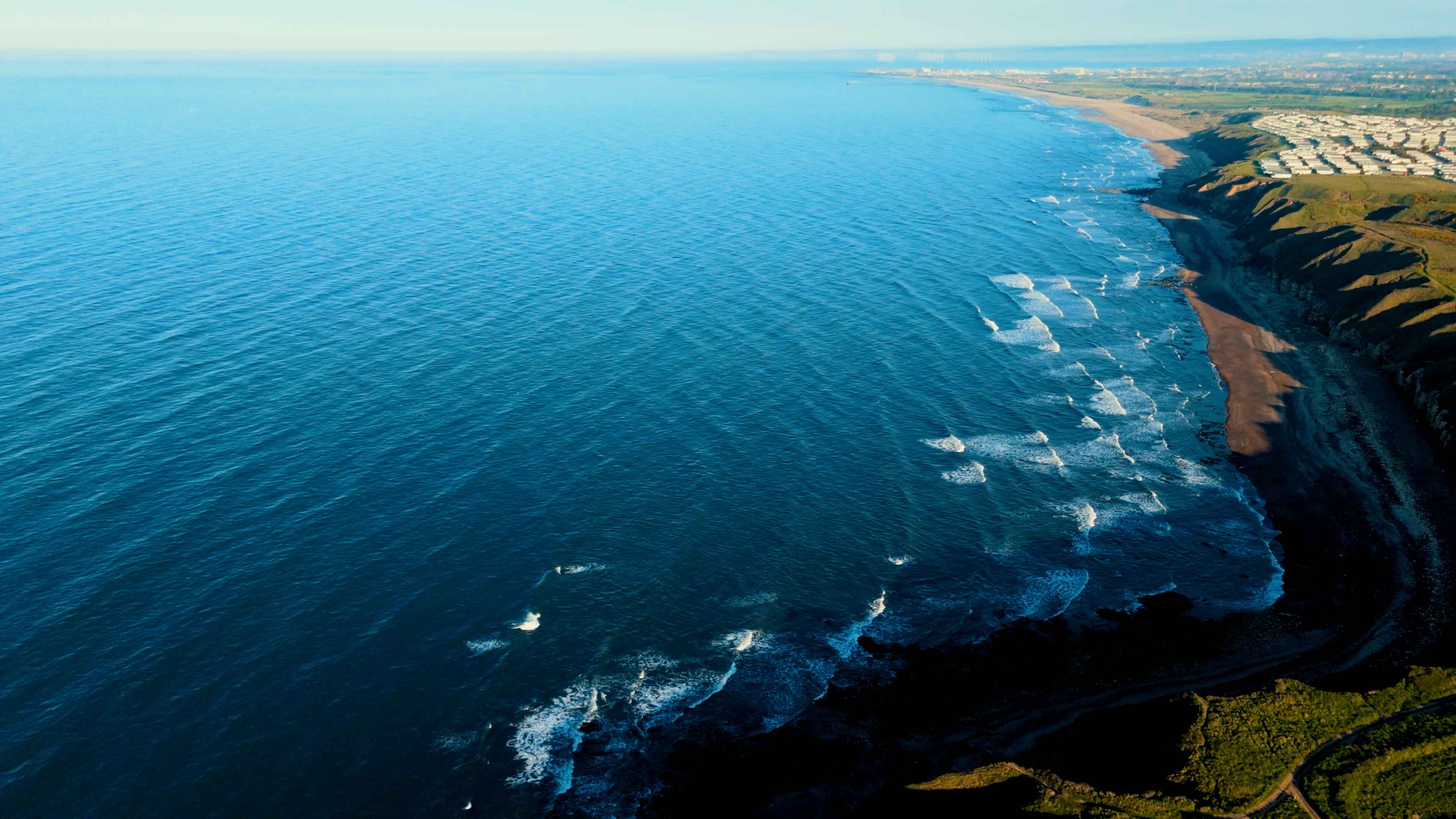 A large body of open water spread across the left of a beachfront