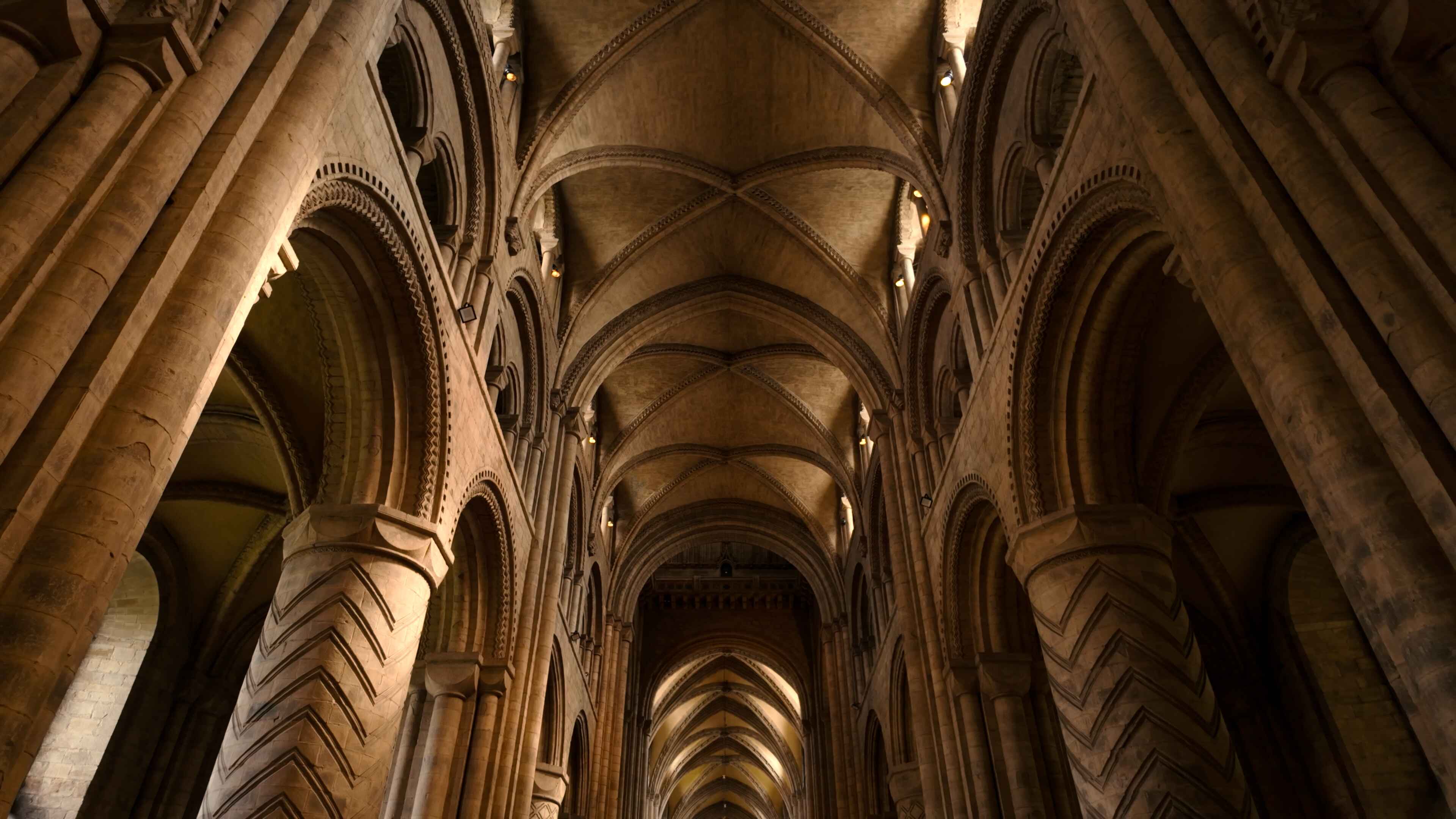 Interior view of a cathedral featuring tall arches and ornate pillars, showcasing intricate architectural details