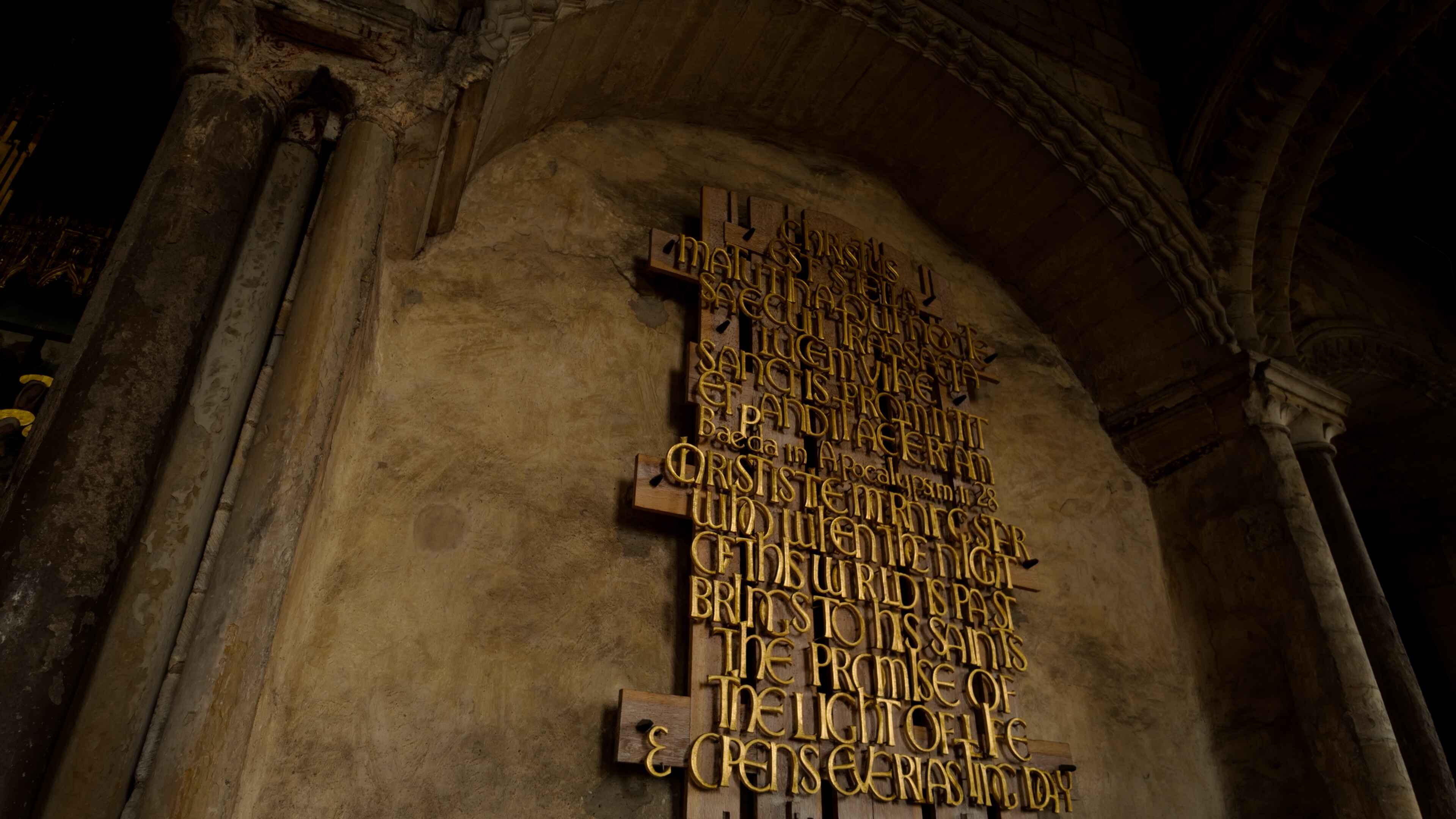 A large wooden plague with brass lettering mounted on it