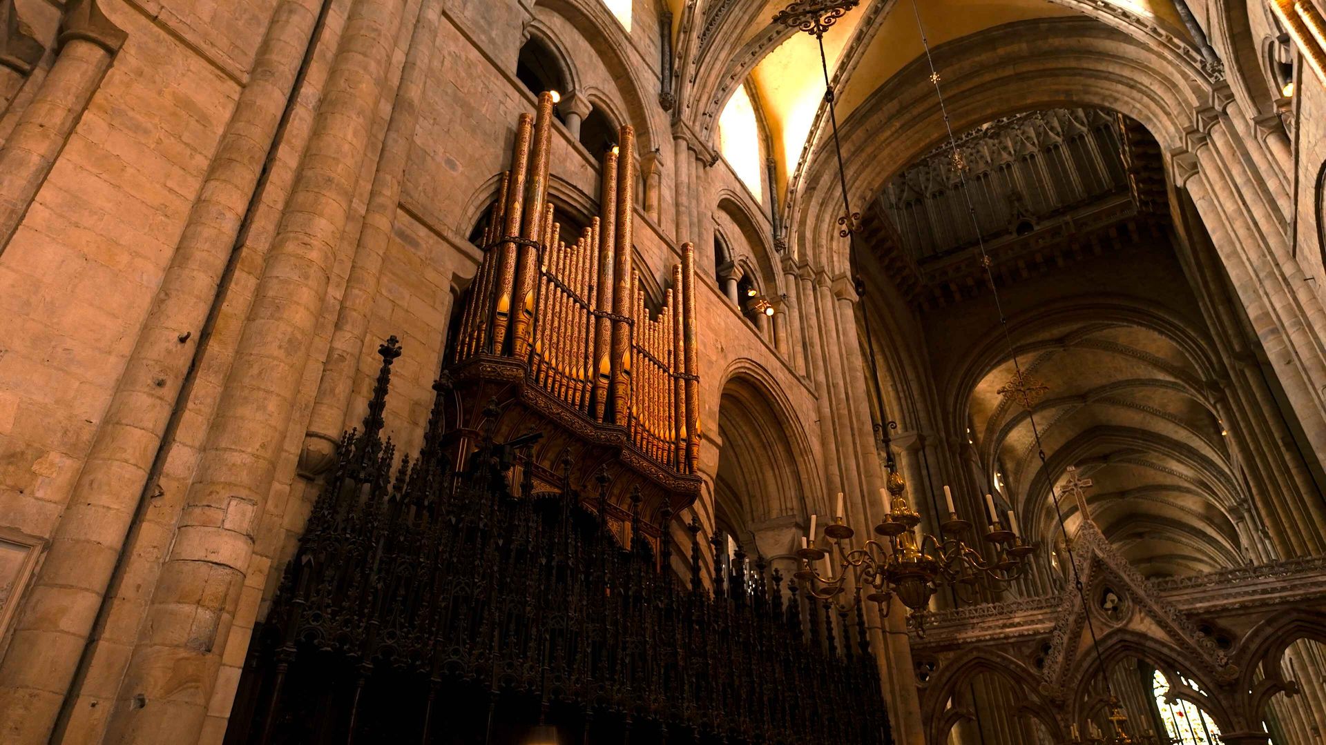 A majestic interior of a cathedral, with intricately designed organ pipes on a wall