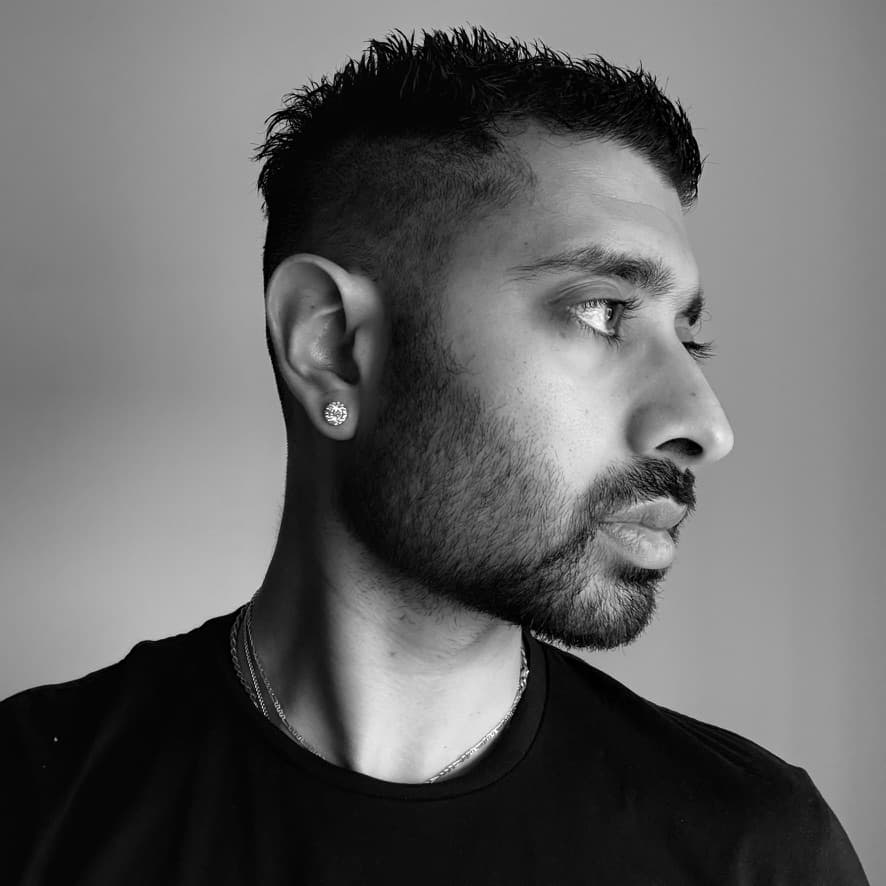 A black and white headshot of a young man looking to the side with neutral expression.